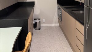 Eine moderne Küche mit schwarzem Arbeitsplatz, Edelstahlgeräten und Holzschränken.