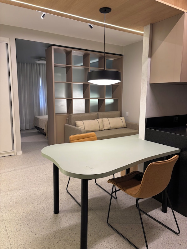 Un comedor moderno con una mesa, sillas y una estantería empotrada.