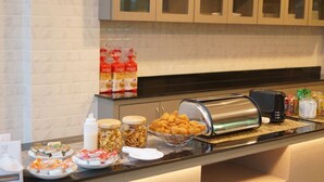 A buffet setup with various food items, including jars of nuts and a bowl of snacks, in a hotel kitchen area. - Mtrio Hotel Korat (Nakhon Ratchasima)