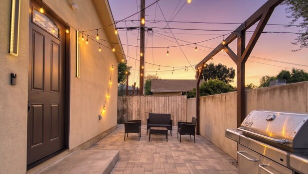 An outdoor patio with a barbecue grill, seating area, and string lights. - Modern 2BR/2BA Guest House in Granada Hills (Los Angeles)