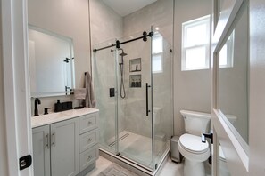 A modern bathroom with a glass-enclosed shower, a toilet, and a vanity with a mirror. - Modern 2BR/2BA Guest House in Granada Hills (Los Angeles)
