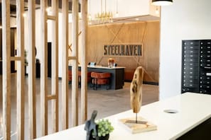 Ein Empfangsschalter mit einer Holzwand, einem Schild mit der Aufschrift 'STEELHEAVEN' und einem modernen Innendesign.