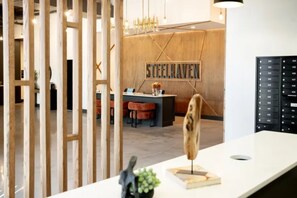 Ein Empfangsschalter mit einer Holzwand, einem Schild mit der Aufschrift 'STEELHEAVEN' und einem modernen Innendesign.