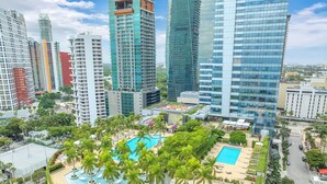 A high-rise building with a rooftop pool surrounded by palm trees. - Luxury Four seasons Hotel Miami 2 Bedroom Oceanview Luxury Suite. (Miami)