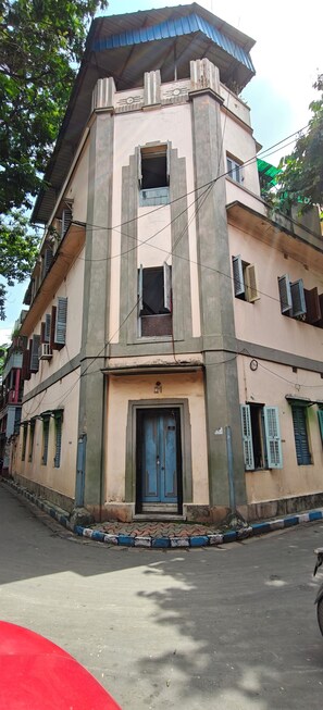 A multi-story building with a central entrance, multiple windows, and a flat roof. - Mudiali Haven: A peaceful 2BHK in South Kolkata - near Kalighat Metro (Kolkata)