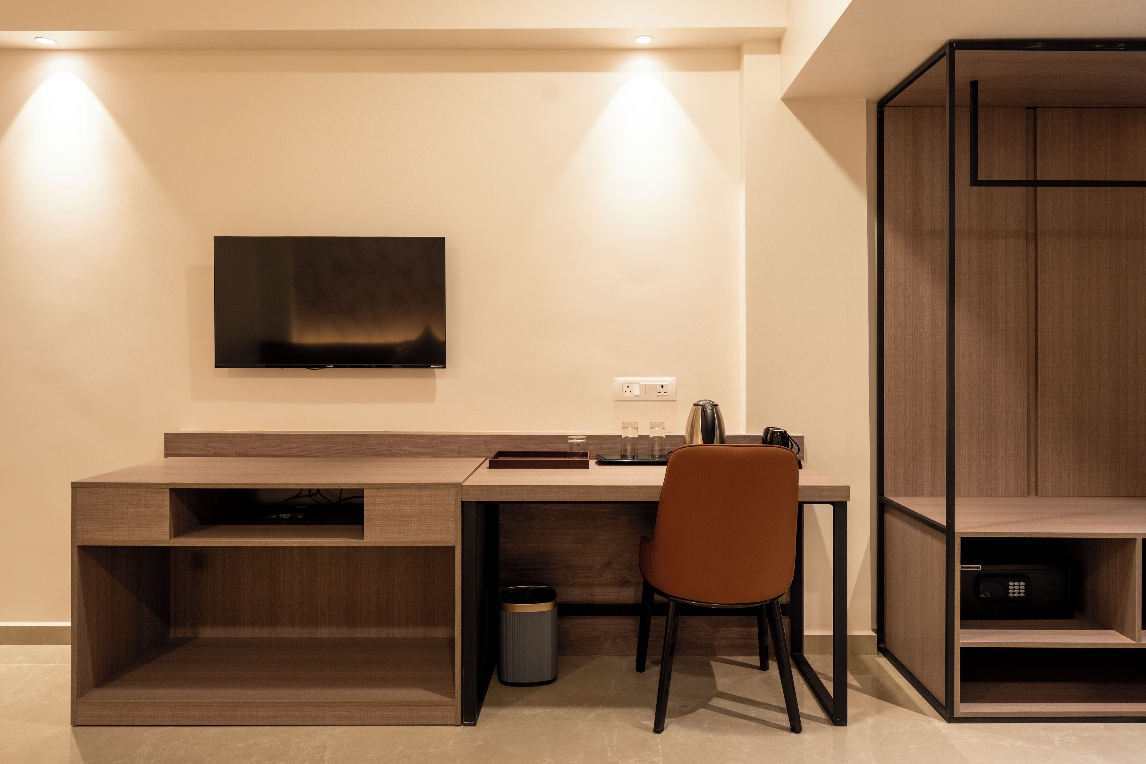 A modern office space with a desk, chair, and a mounted television.