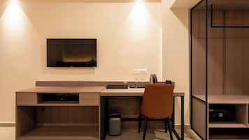 A modern office space with a desk, chair, and a mounted television.