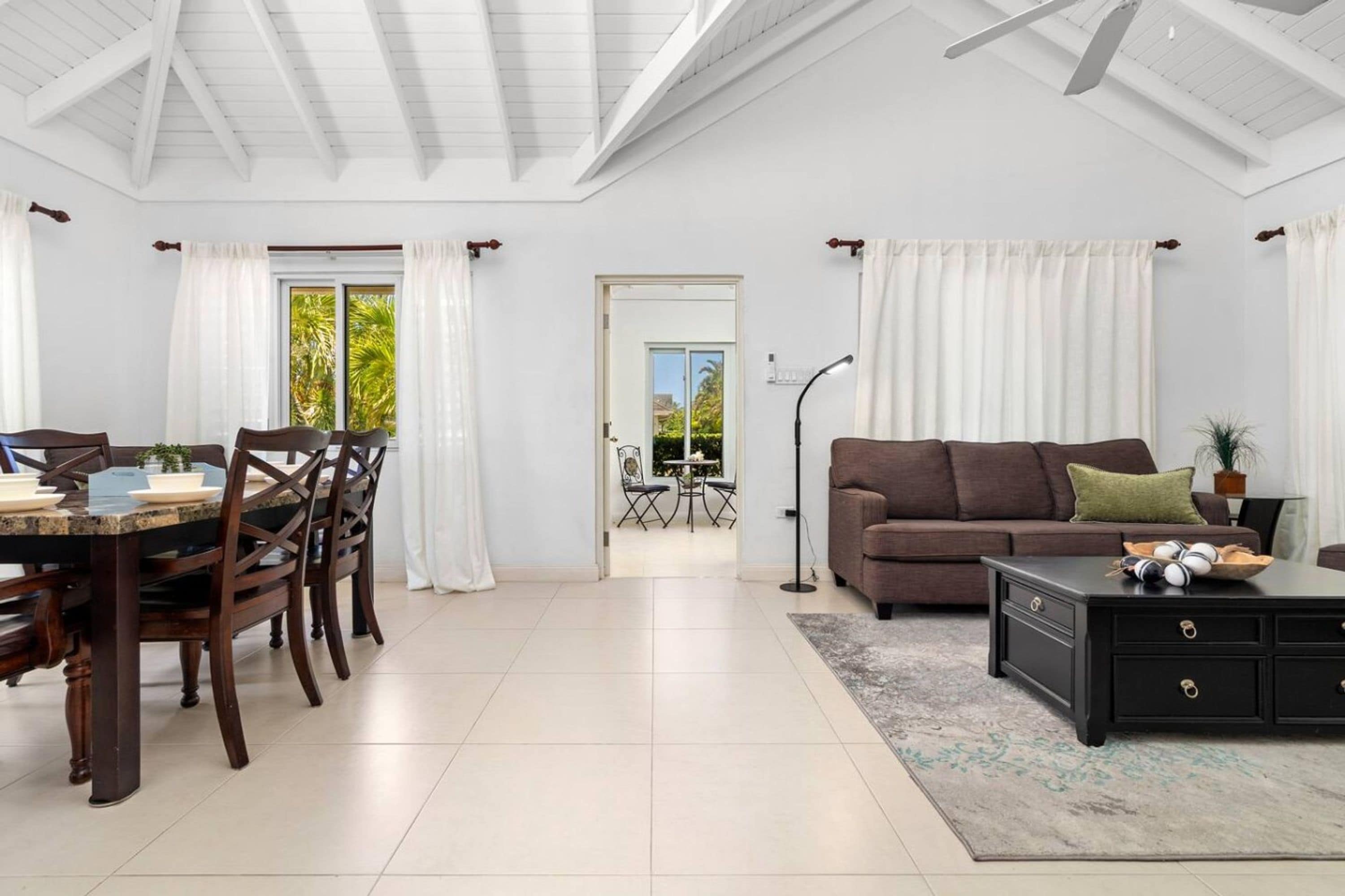 Ampla sala de estar com mesa de jantar, cadeiras, sofá e mesa de centro.