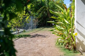 A pathway leading to a fenced area with greenery and a building on the right. - Richmond Retreat Pool Gym Gated Beach Access (St. Ann's Bay)