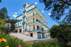 A multi-story building with balconies, a staircase, and a surrounding garden. - Chaitanya Homes Kasauli (Kasauli)
