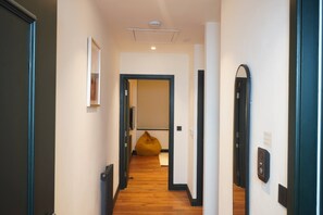 A hallway with a radiator, a mirror, and a yellow bean bag chair. - Chic Exposed-brick 1BR - Manchester Centre - Gym (Manchester)