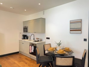 A compact kitchen with a dining area, featuring a microwave, coffee maker, and a small sink. - Chic Exposed-brick 1BR - Manchester Centre - Gym (Manchester)