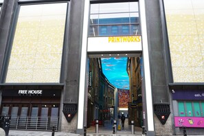 A building entrance with a sign for 'PRINTWORKS' and a 'FREE HOUSE' sign. - Chic Exposed-brick 1BR - Manchester Centre - Gym (Manchester)