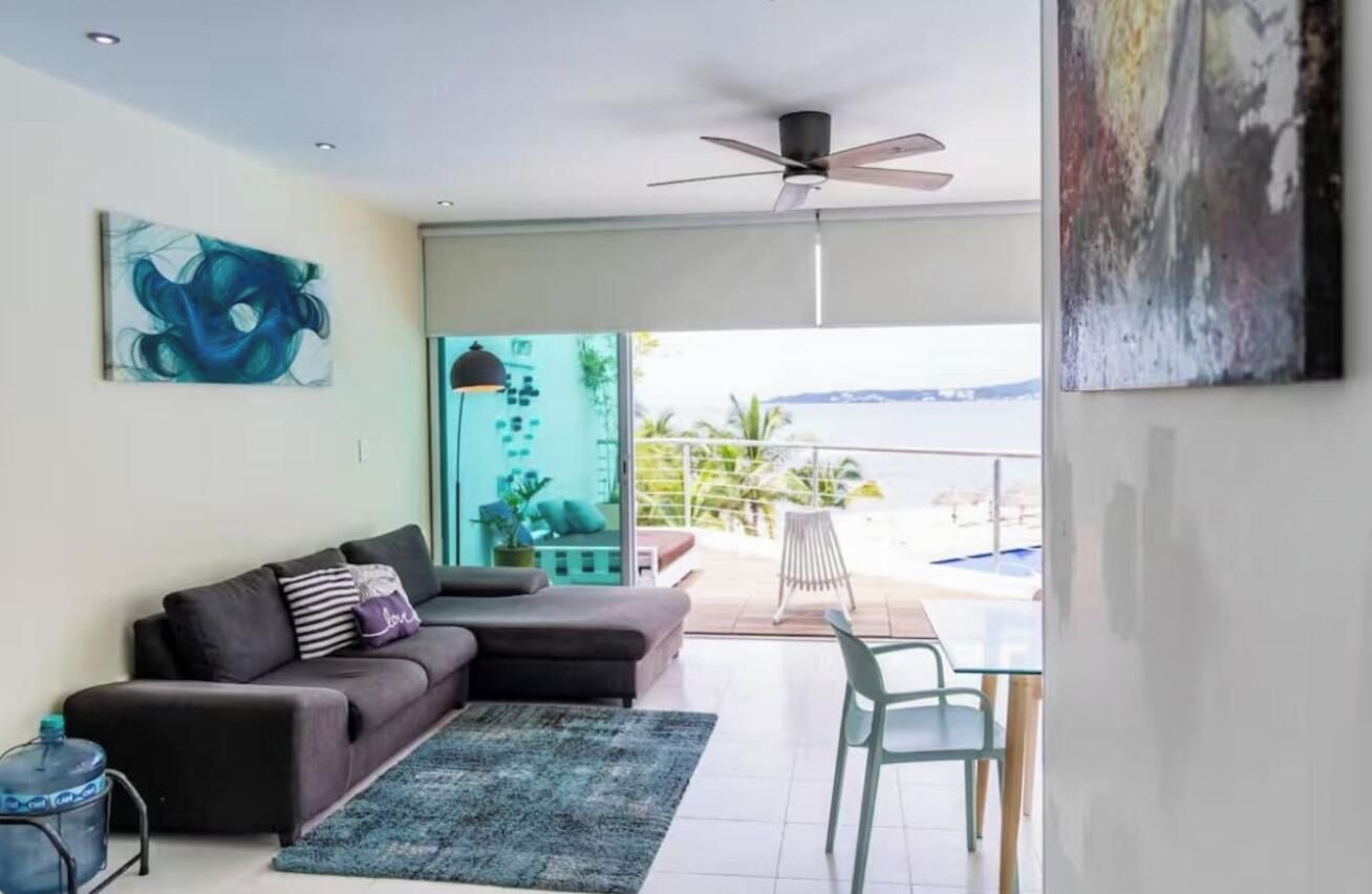 Un salon moderne avec un canapé, une table en verre et une vue sur la mer.
