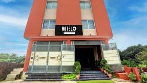 A hotel with a prominent 'HOTEL' sign, a company-serviced logo, and a modern facade with a flat roof. - Super Hotel O New Marine Drive Puri (Puri)