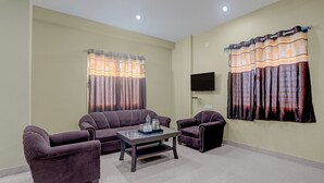 A living room with a sofa, armchairs, and a coffee table. - Super Hotel O New Marine Drive Puri (Puri)
