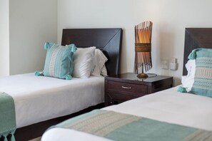 A hotel room with two beds, a nightstand, a lamp, and a wall-mounted light fixture. - Depto. Playa Vista Mar Villa Magna Nuevo Vallarta (Nuevo Nayarit)