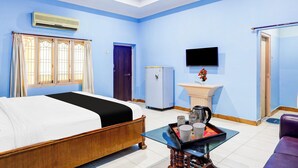 A hotel room with a bed, a small table with a tray, a sink, a television, and a door. - Hotel O Rayagada Downtown (Rayagada)
