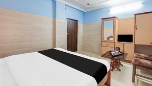 A hotel room with a bed, a desk, a chair, a wardrobe, and a television. - Hotel O Rayagada Downtown (Rayagada)