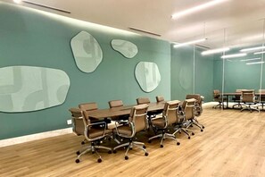 A conference room with a long table, chairs, and abstract wall art. - Luxury Bolongo Beachfront Apartment in Punta Mita (Corral del Risco)