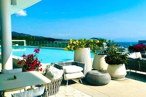 A rooftop terrace with a pool, outdoor seating, and potted plants. - Luxury Bolongo Beachfront Apartment in Punta Mita (Corral del Risco)