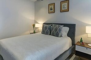 A hotel room with a bed, a nightstand with a lamp, and two framed pictures on the wall. - Luxury Bolongo Beachfront Apartment in Punta Mita (Corral del Risco)