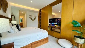 Una camera da letto moderna con un letto, comodini, una TV e una pianta.