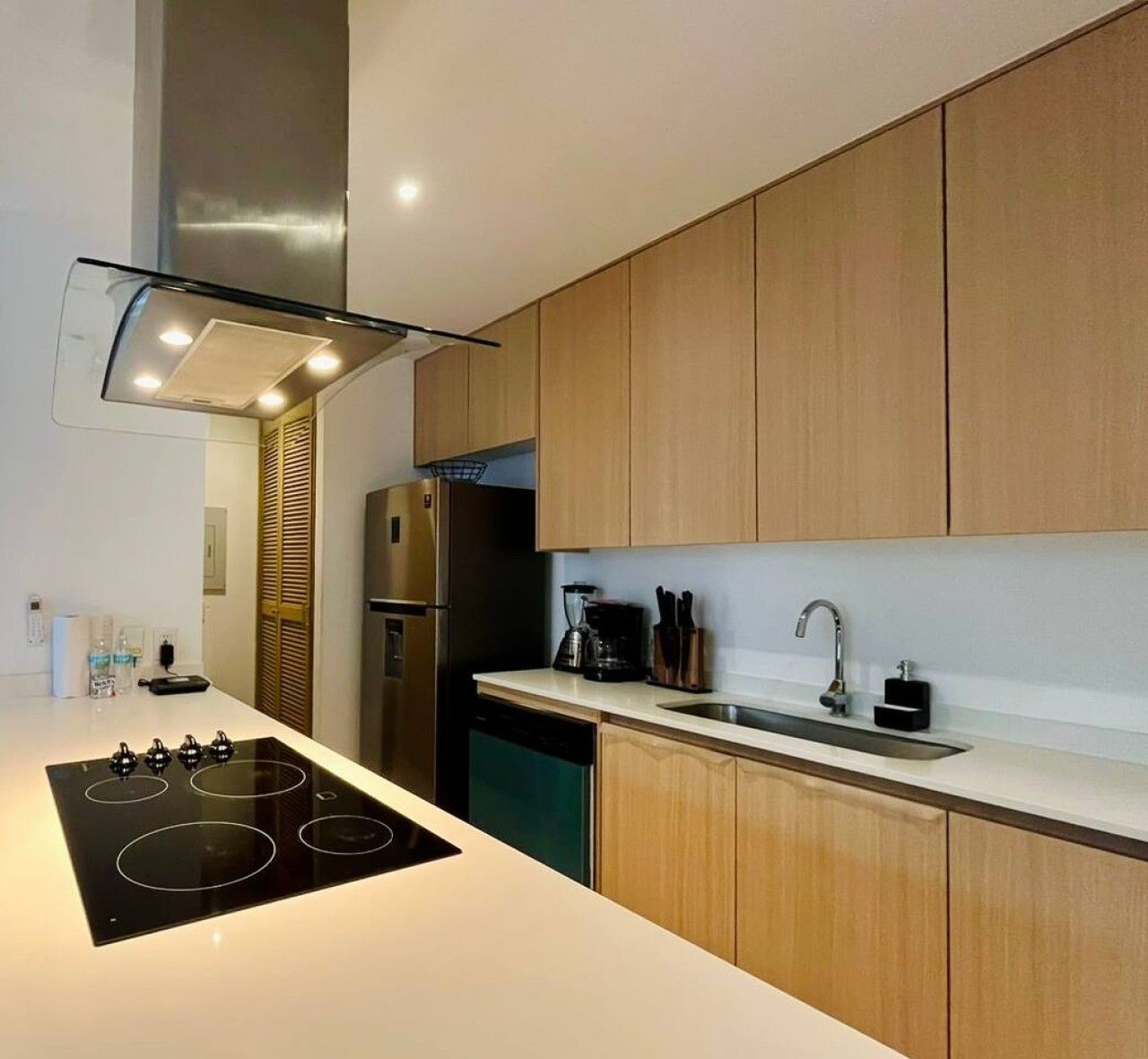 A modern kitchen with a central island, stainless steel appliances, and wooden cabinetry.