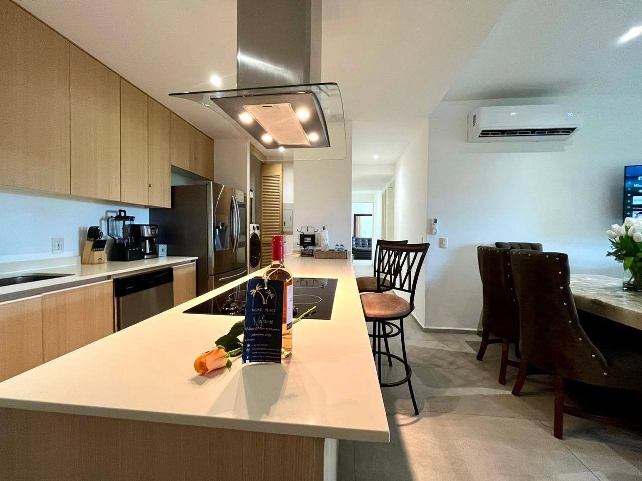 A modern kitchen with a central island, built-in appliances, and a dining area with bar stools.