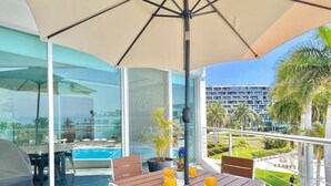 Un balcone con tavolo, sedie e vista sulla piscina.