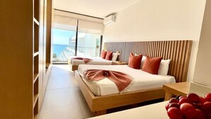 Une chambre d’hôtel moderne avec deux lits, une tête de lit en bois et une vue sur le paysage urbain.