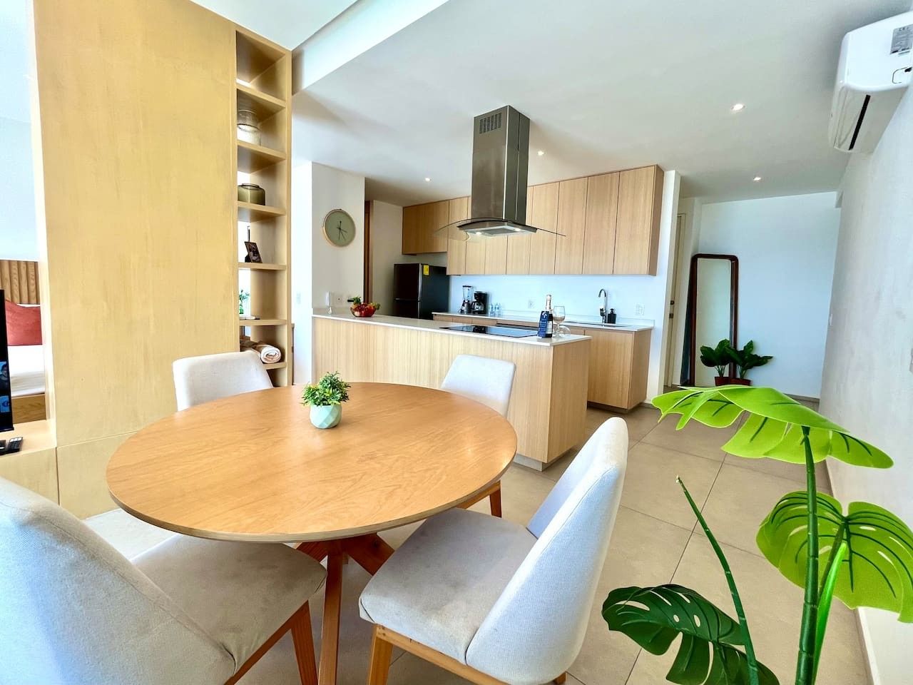 A modern kitchen with wooden cabinets, a central island, and a built-in stove.