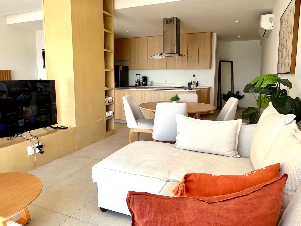 Un salon moderne avec un canapé, une table basse et un téléviseur.