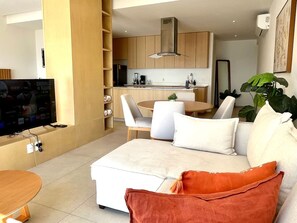 Una sala de estar moderna con un sofá, una mesa de centro y un televisor.