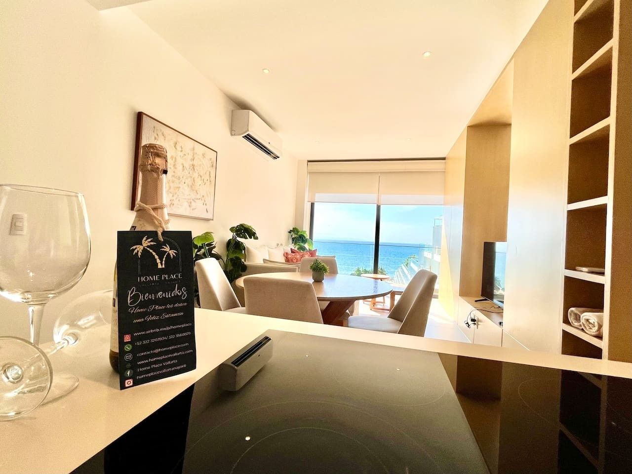 Een moderne hotelkamer met een zithoek, uitzicht op zee en een minibar.