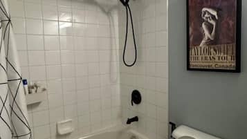 Une salle de bain avec une baignoire, des toilettes et un pommeau de douche.