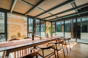 A modern interior with a long wooden bar, seating, and large windows. - Harbor City (Universal Beijing Resort) (Tongzhou)