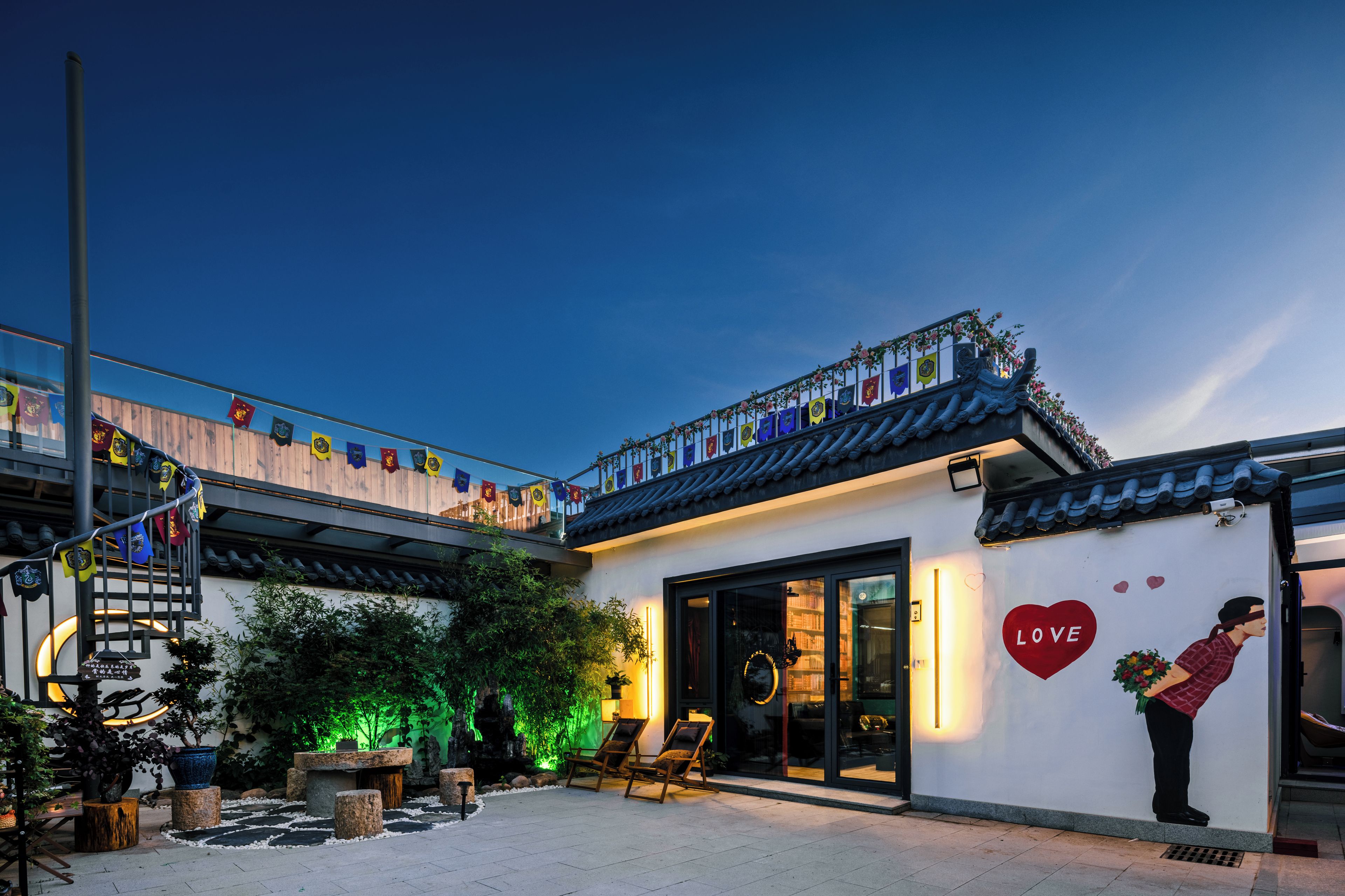 Un edificio con arquitectura tradicional, un balcón con banderas y una decoración con forma de corazón en la pared.