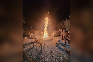Una chimenea con asientos a su alrededor, ubicada sobre una superficie de grava.