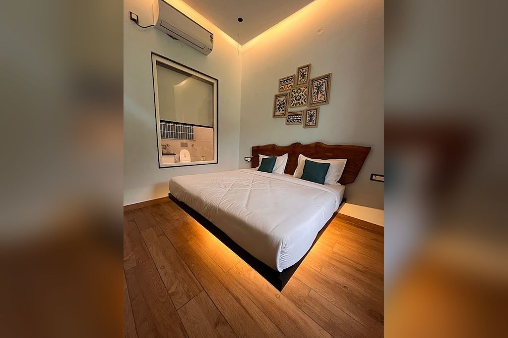 Un dormitorio con una cama grande, aire acondicionado de pared y un espejo que refleja parte de la habitación.