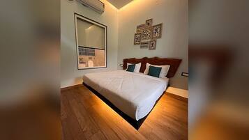 Un dormitorio con una cama grande, aire acondicionado de pared y un espejo que refleja parte de la habitación.