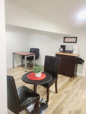 A small, furnished room with a dining table, two chairs, a coffee station, and a cabinet. - Central Cozy Haven! Private Room, Self Check-In, U of A, NAIT (Edmonton)