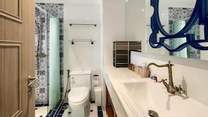 Un baño con una bañera blanca, un espejo grande y baldosas con diseño.