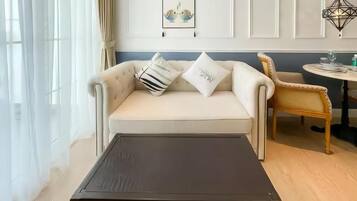 A living room with a sofa, a coffee table, a chair, and a wall-mounted picture.