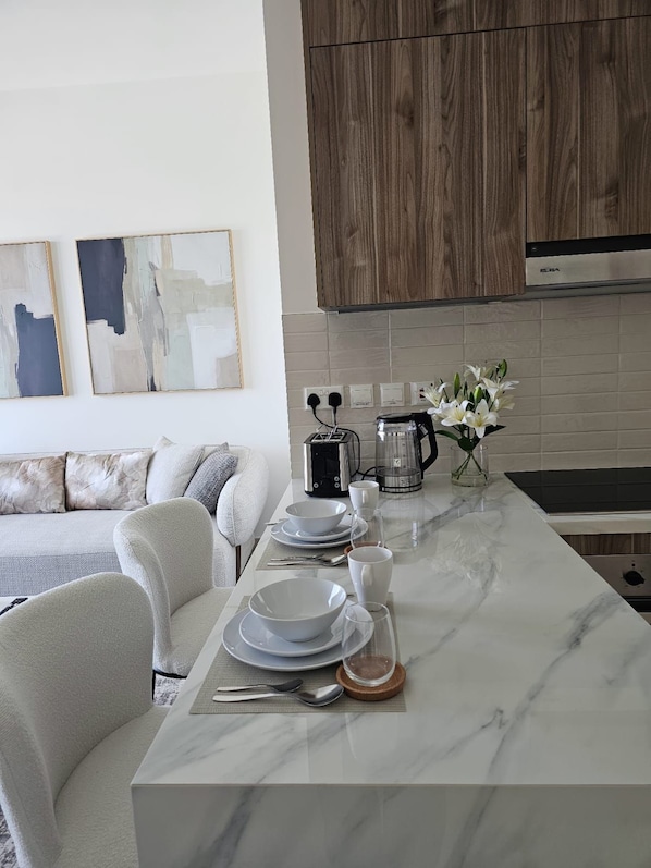 A modern kitchen with a marble countertop, a coffee maker, and a toaster.