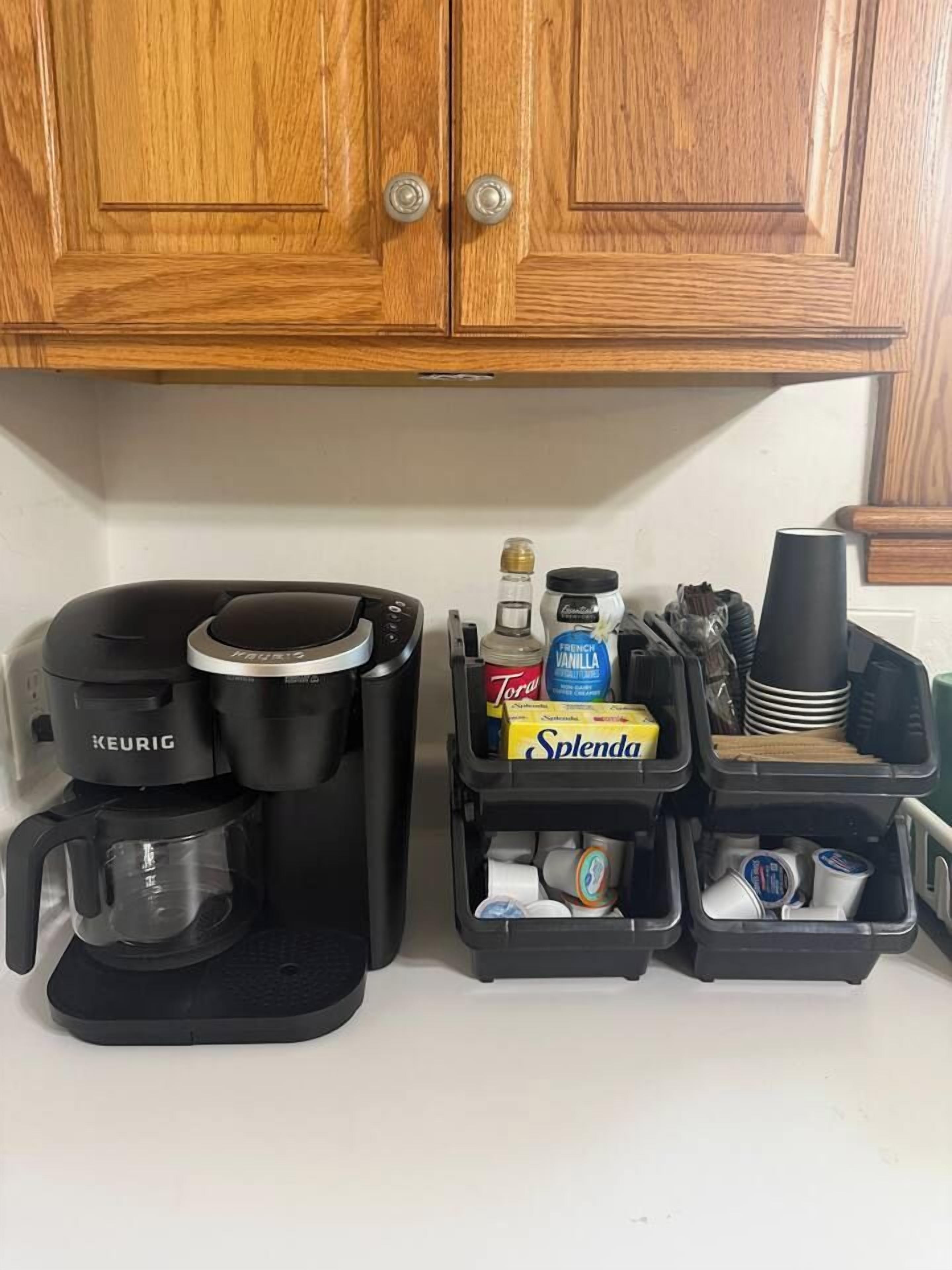 A kitchen with a Keurig coffee maker, a bottle of French vanilla syrup, and a Splenda box.