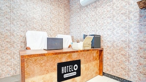 Eine Hotelrezeption mit einem Schild, auf dem 'HOTELO Company-Serviced' steht.