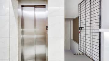 En elevator med metalfinish og et kontrolpanel med knapper.
