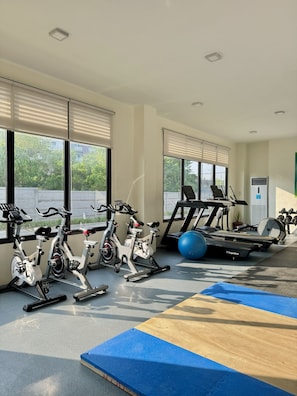 Una palestra con cyclette, tapis roulant e palle da ginnastica.