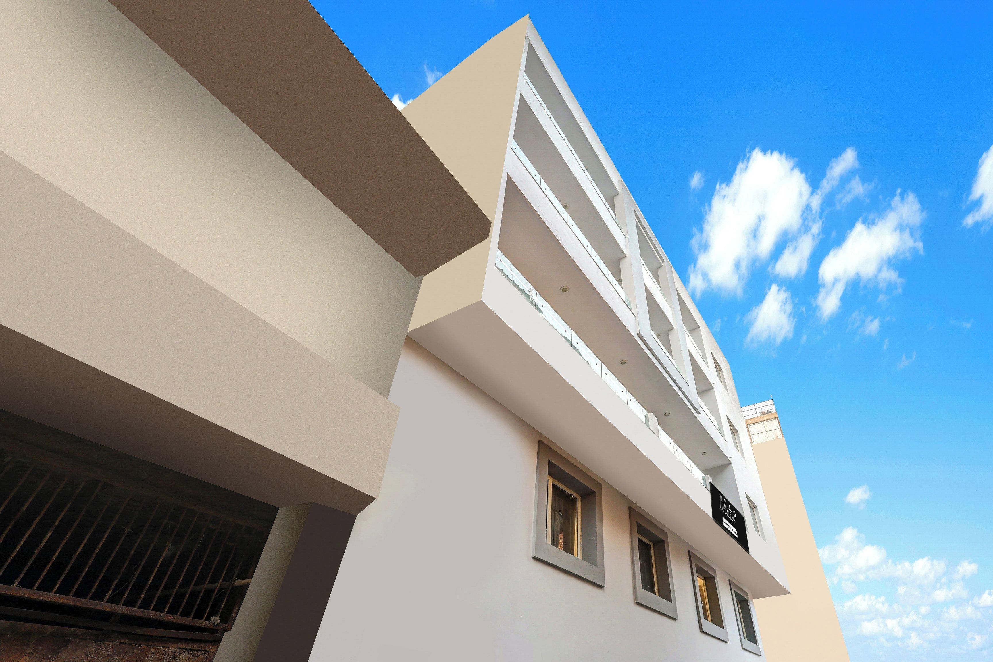 Un edificio de varios pisos con fachada plana, ventanas amplias y cielo despejado.